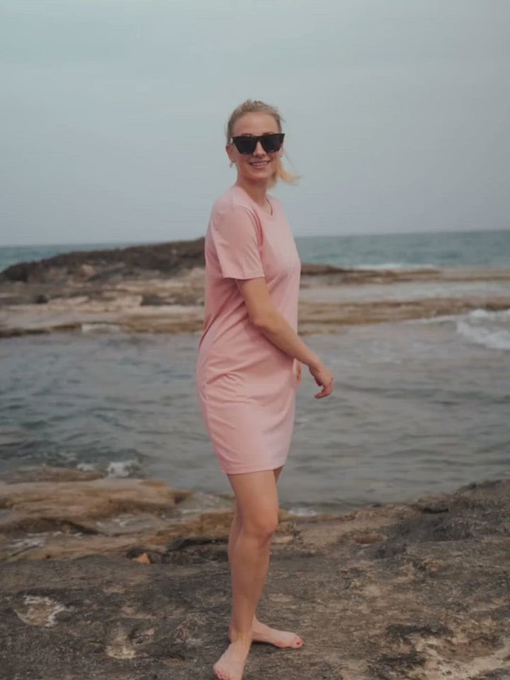 Marbella dámské letní šaty z biobavlny růžové kulatý výstřih s rukávy žena se otáčí na útesu u moře