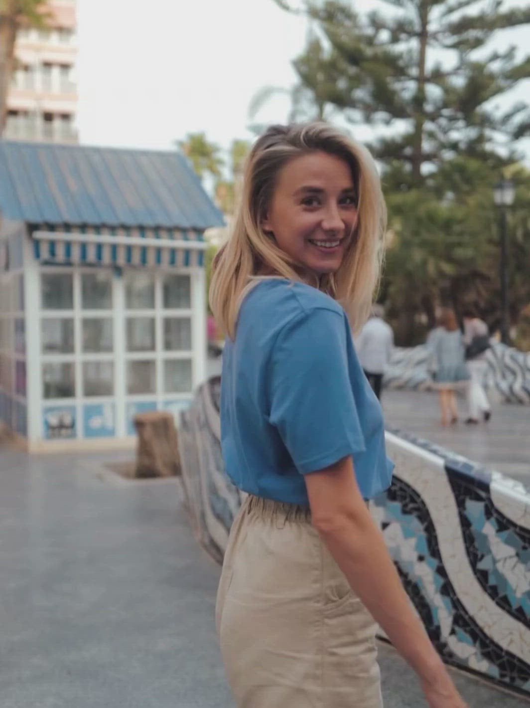 Cape dámské tričko z biobavlny s kulatým výstřihem modré blonďatá žena s úsměvem se otáčí na ulici