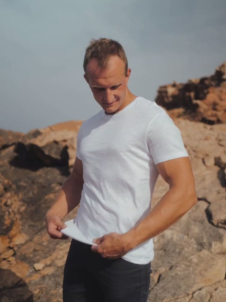 Touch pánské s-lub tričko z biobavlny s kulatým výstřihem bílé muž stojí na útesu s vlajícím tričkem