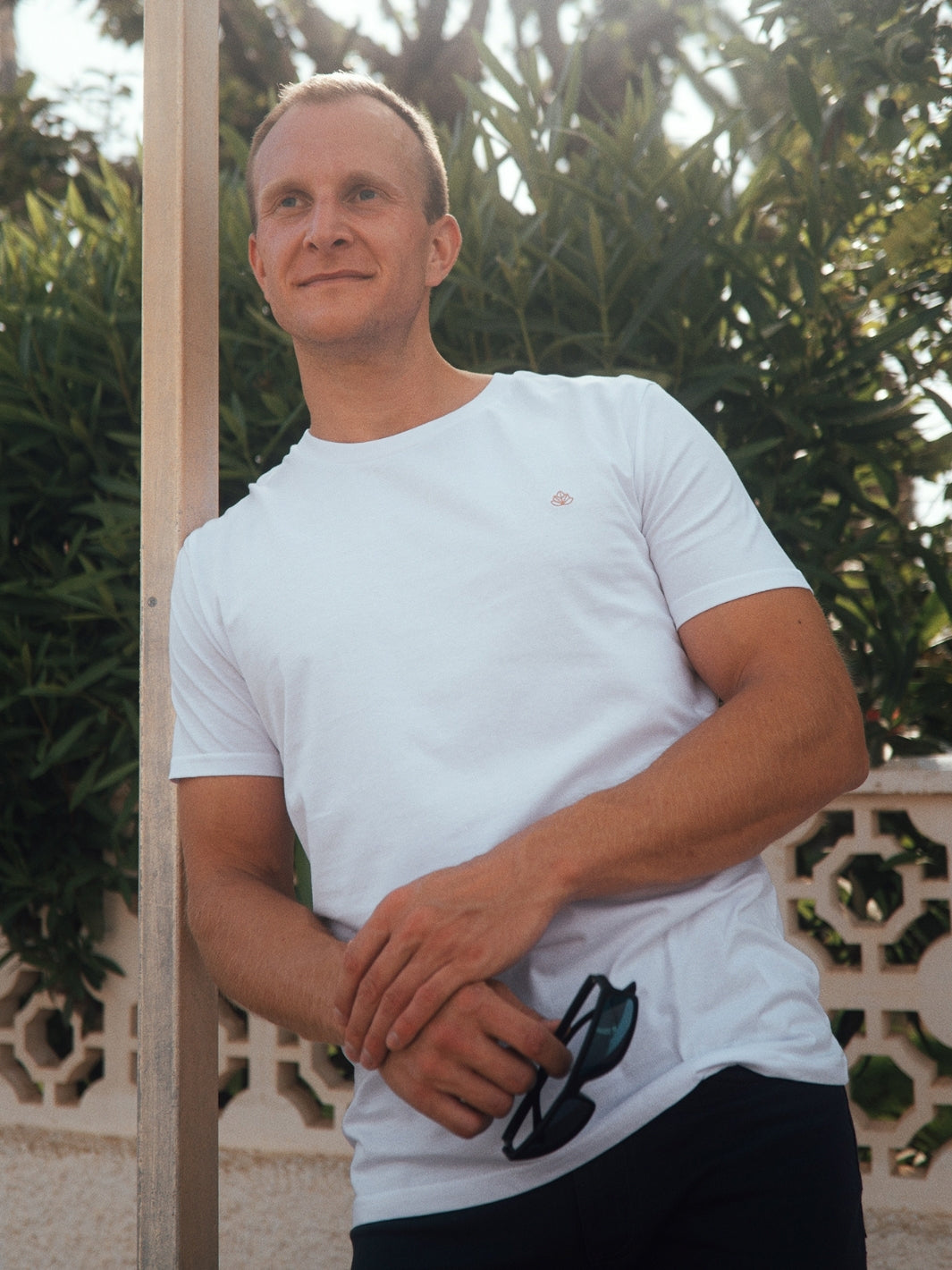 Feel pánské tričko z biobavlny s kulatým výstřihem bílé opřený muž drží v ruce brýle