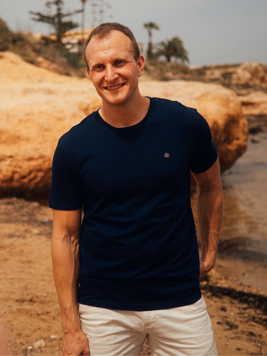 Feel pánské tričko z bio bavlny s kulatým výstřihem námořní modré muž je na pláži a usmívá se