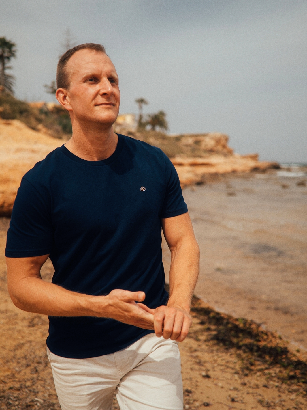 Feel pánské tričko z bio bavlny s kulatým výstřihem námořní modré muž jde po pláži u moře