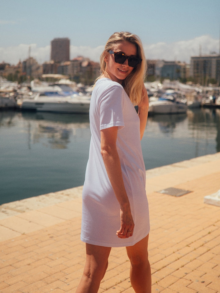 Marbella dámské letní šaty z biobavlny bílé kulatý výstřih s rukávy holka otočená zády v přístavu