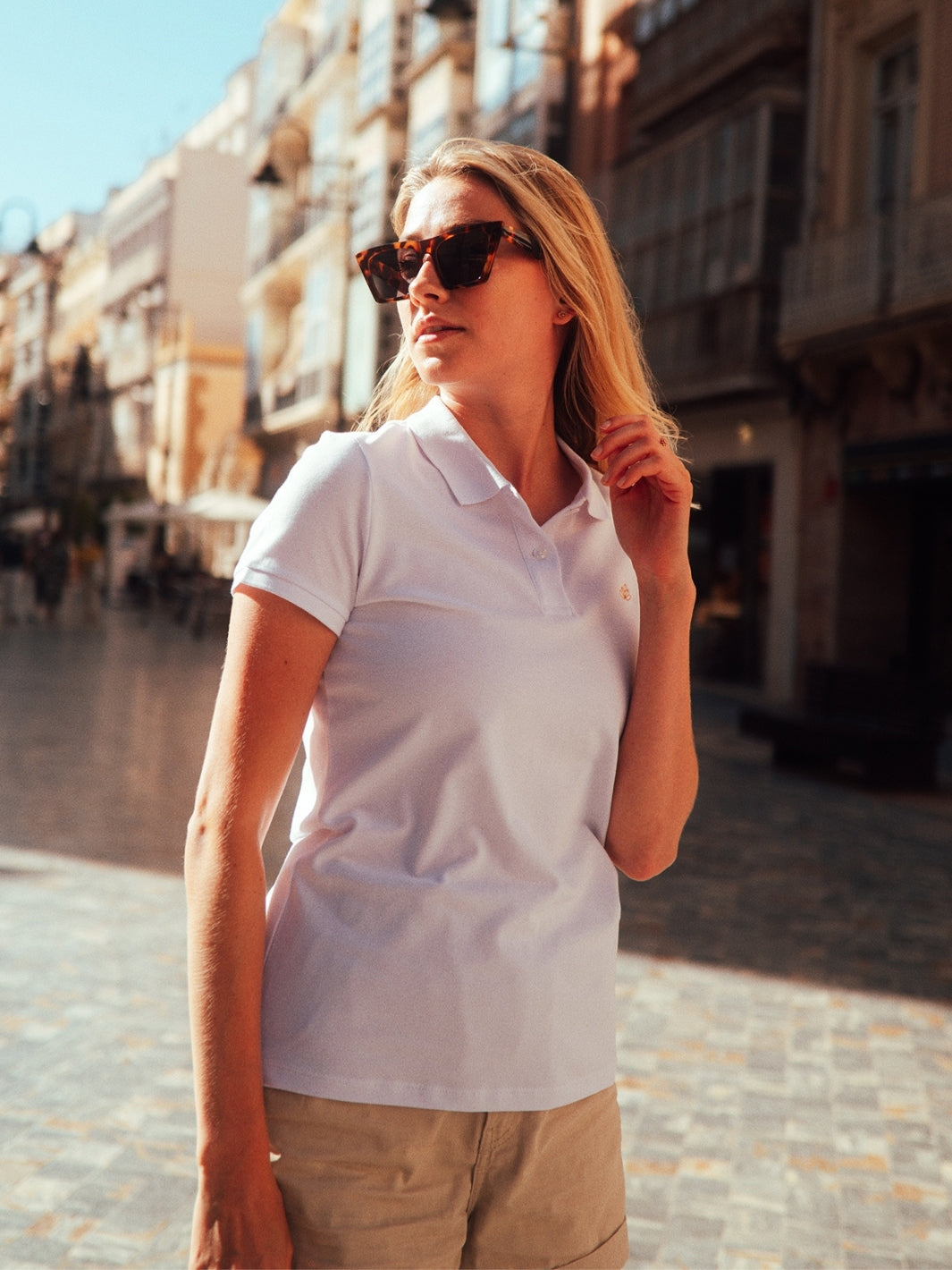 Milano dámské polo tričko z biobavlny bílé blondýnka si drží vlasy ve městě