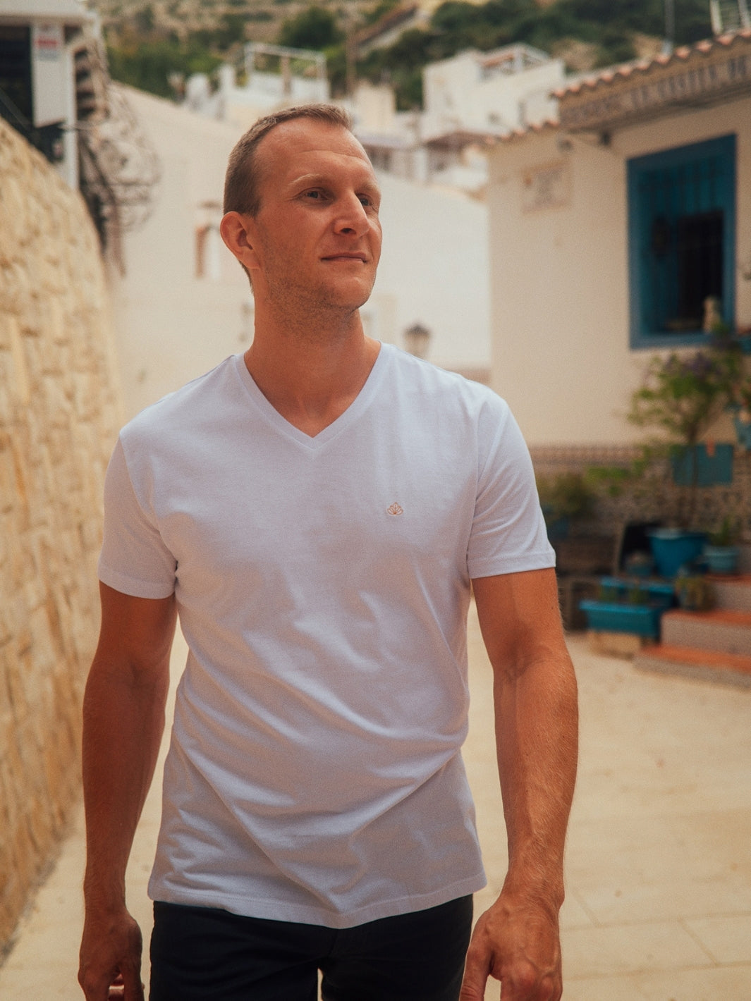 Sanremo pánské tričko s výstřihem do V z biobavlny bílé muž jde po ulici