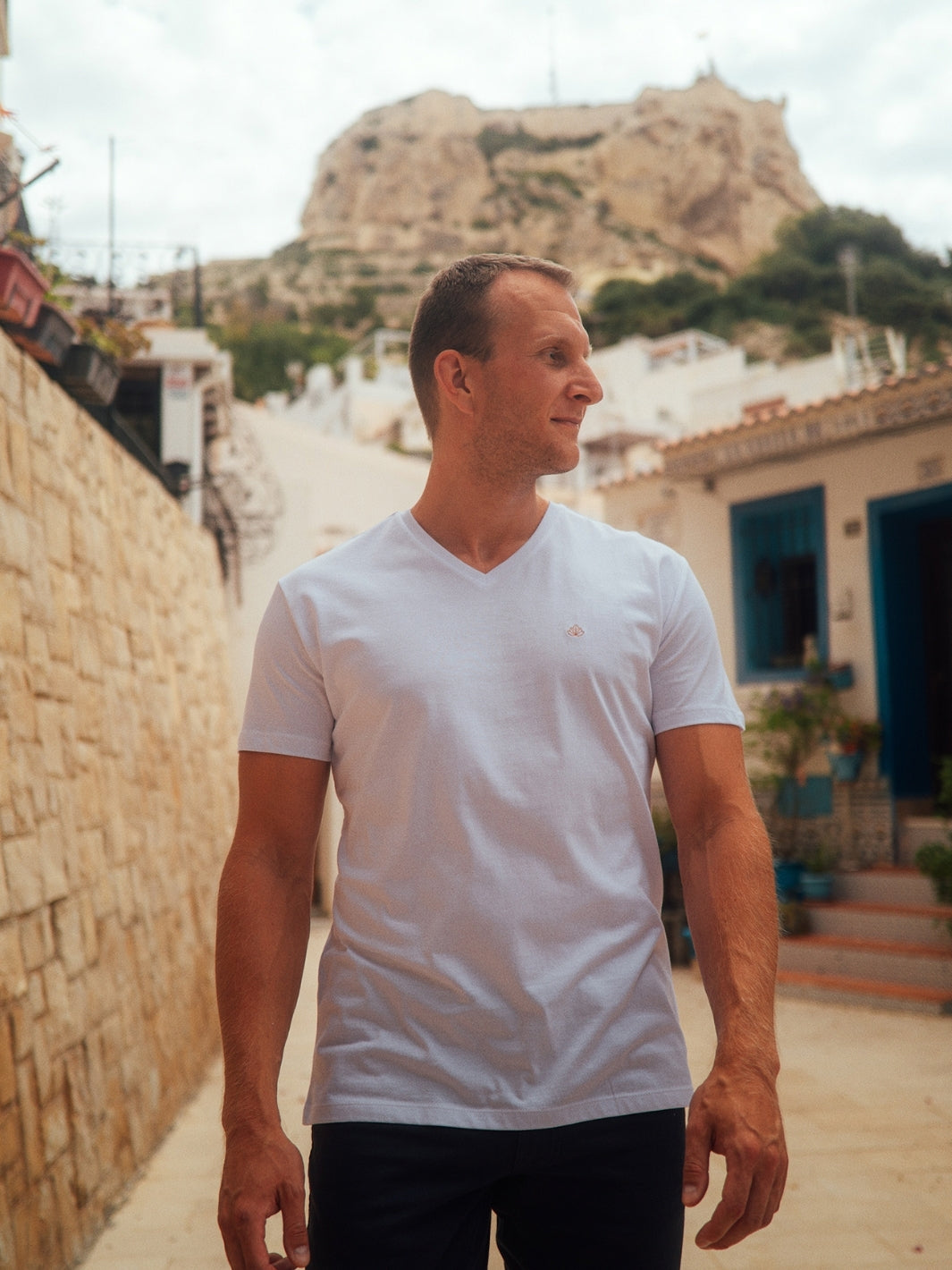 Sanremo pánské tričko s výstřihem do V z biobavlny bílé muž s pozadím kopce