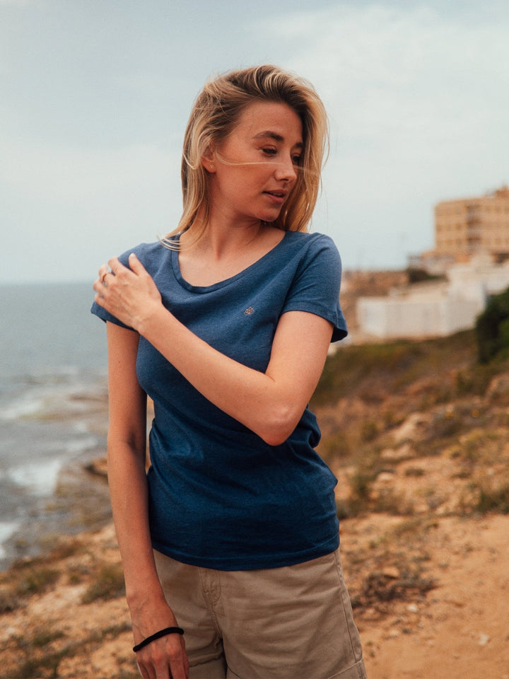 Soul 2.0 dámské tričko z bio bavlny s kulatým výstřihem modré žíhané holka si drží rameno na útesu u moře