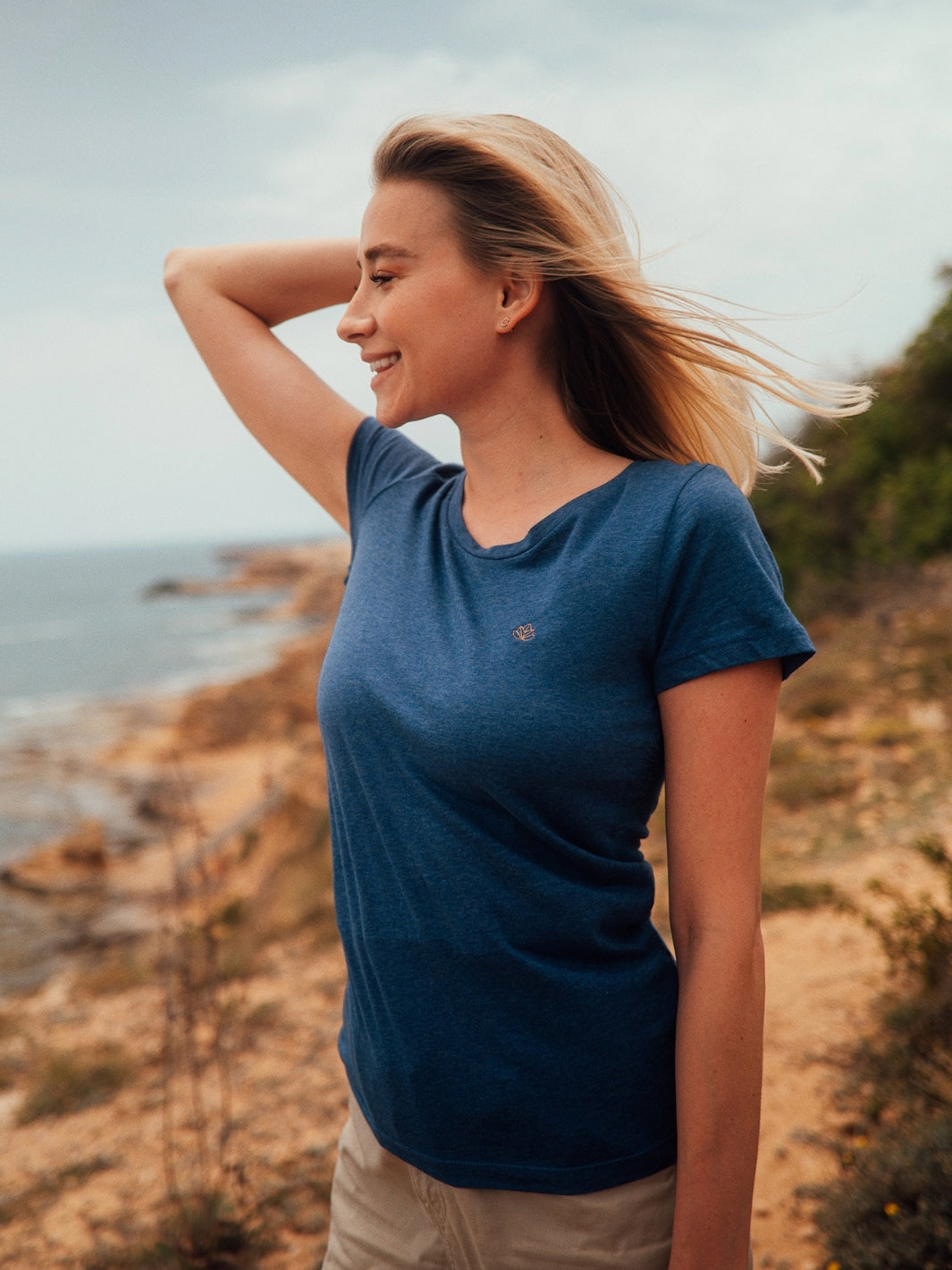 Soul 2.0 dámské tričko z bio bavlny s kulatým výstřihem modré žíhané žena kouká do dálky na útesu u moře