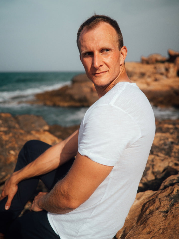 Touch pánské s-lub tričko z biobavlny s kulatým výstřihem bílé muž sedí na útesu a kouká přes rameno